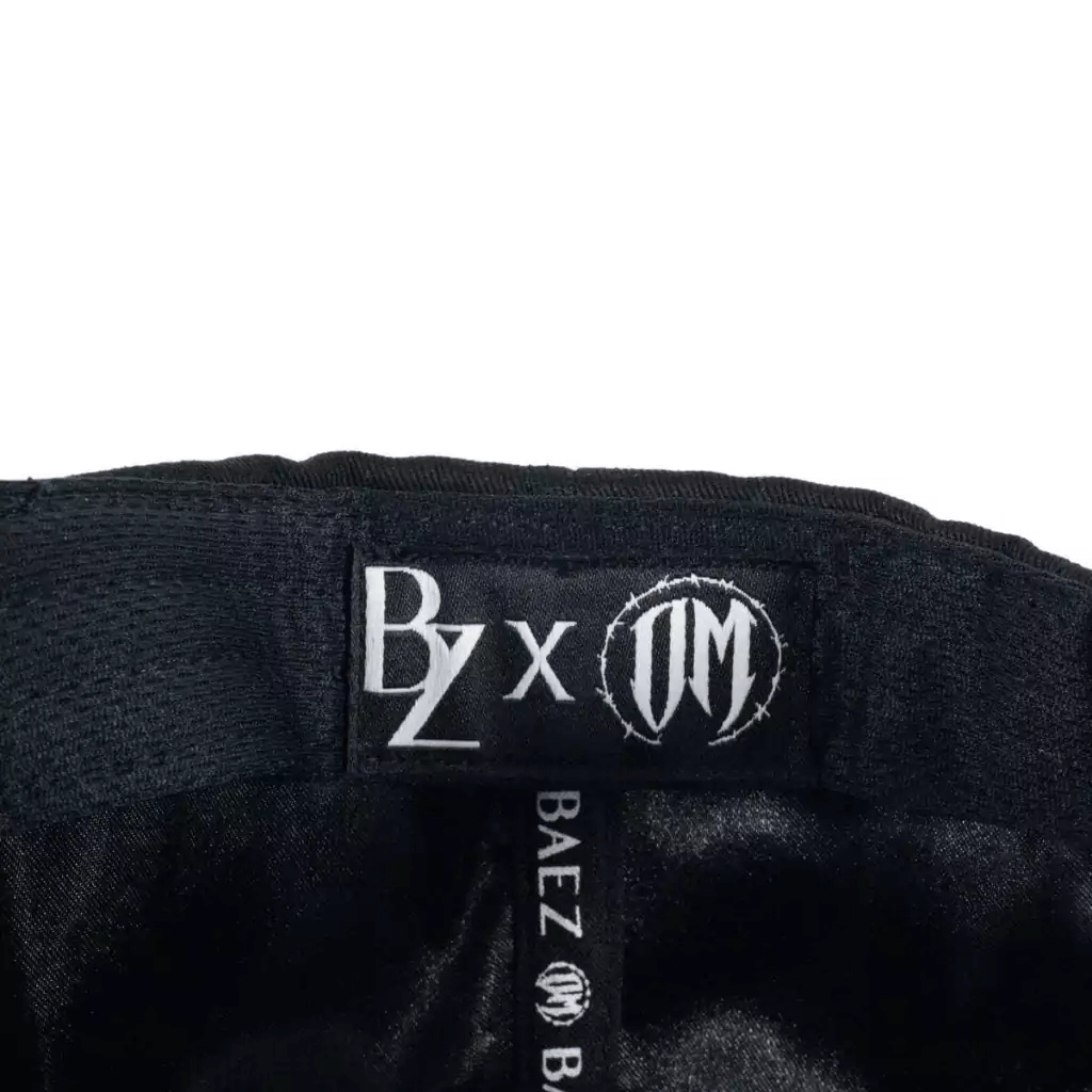 BAEZ x OSCAR MAYDON "QUIEN ME CUIDA NO DUERME" GORRA AJUSTABLE NEGRA