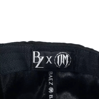 BAEZ x OSCAR MAYDON "QUIEN ME CUIDA NO DUERME" GORRA AJUSTABLE NEGRA